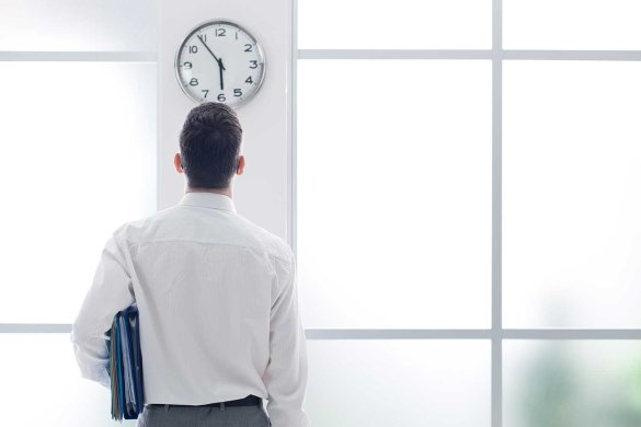 A man looking at an office clock