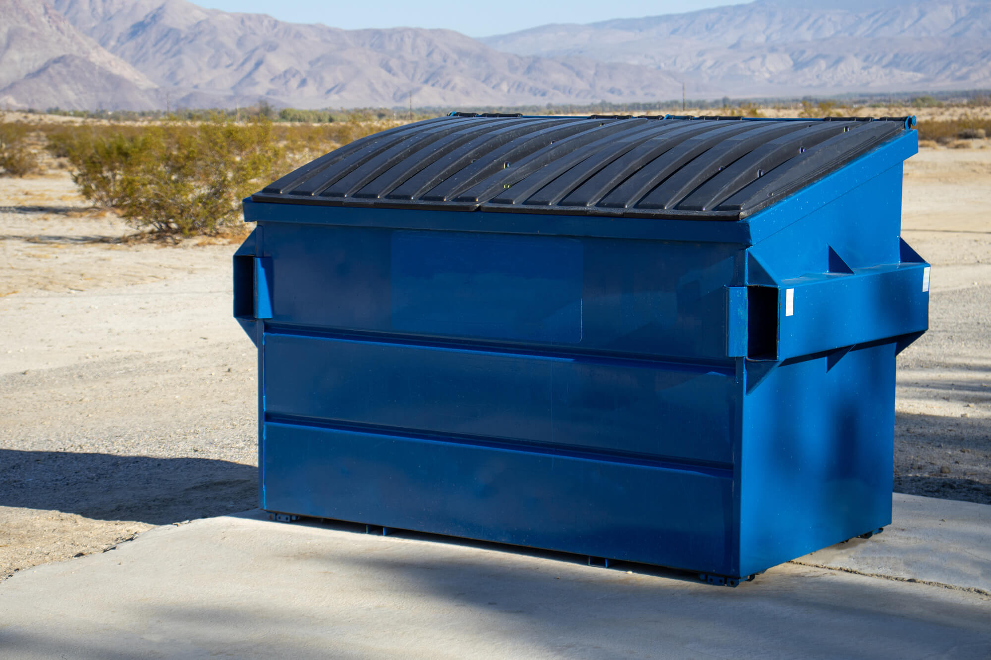 A large blue commercial dumpster for trash or recycling.