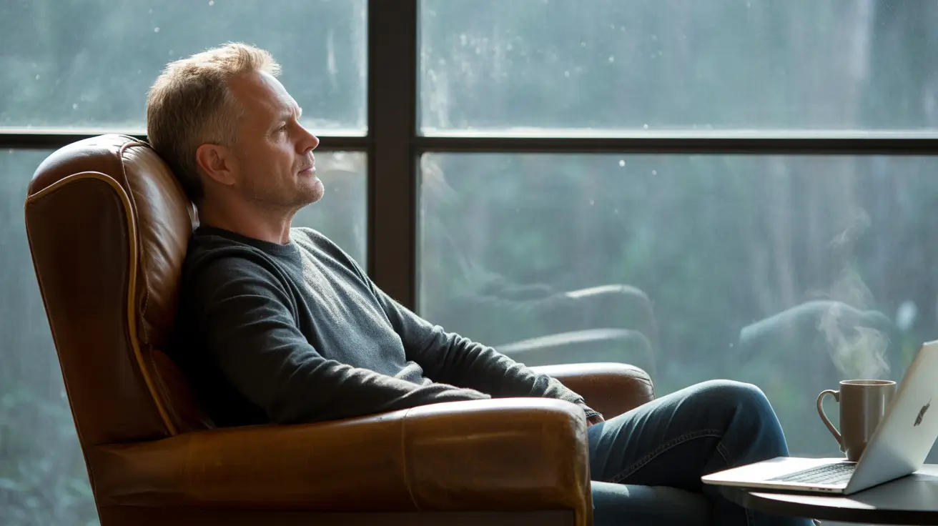 A photograph of a man with short, salt-and-pepper hair, leaning back against a worn leather armchair.